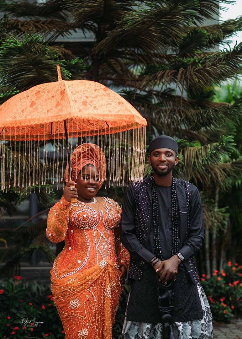 Couple beneath a traditional beaded umbrella